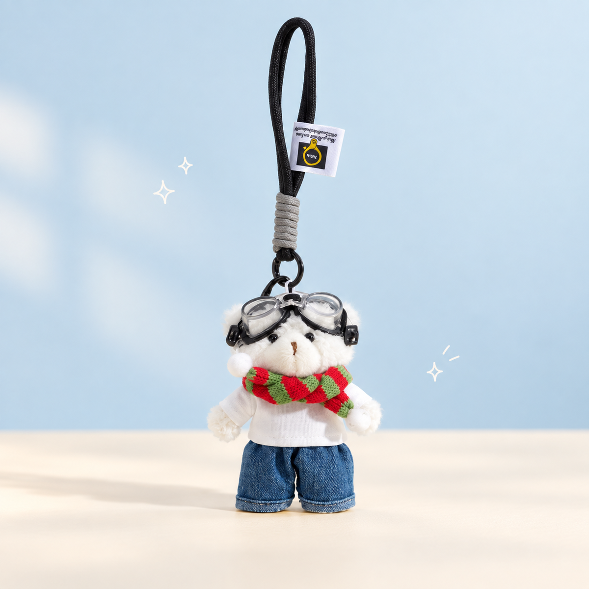 Aviator Bear Plush Charm on a softly lit cream and pastel background.