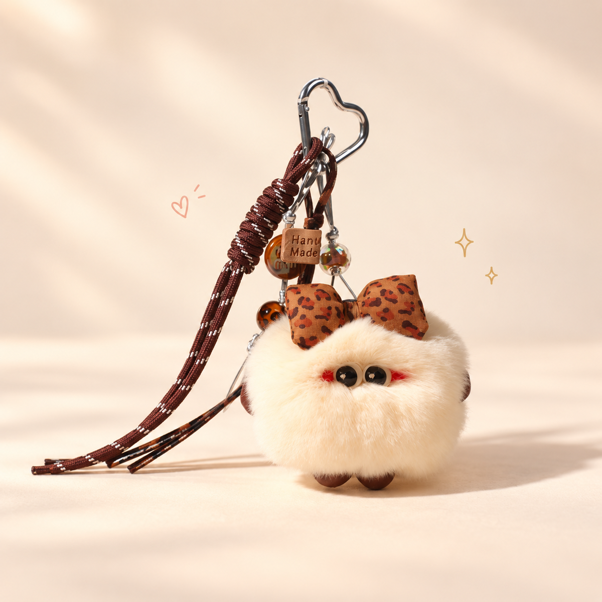 Bow Bun Plush Keychain on a softly lit cream and pastel background.