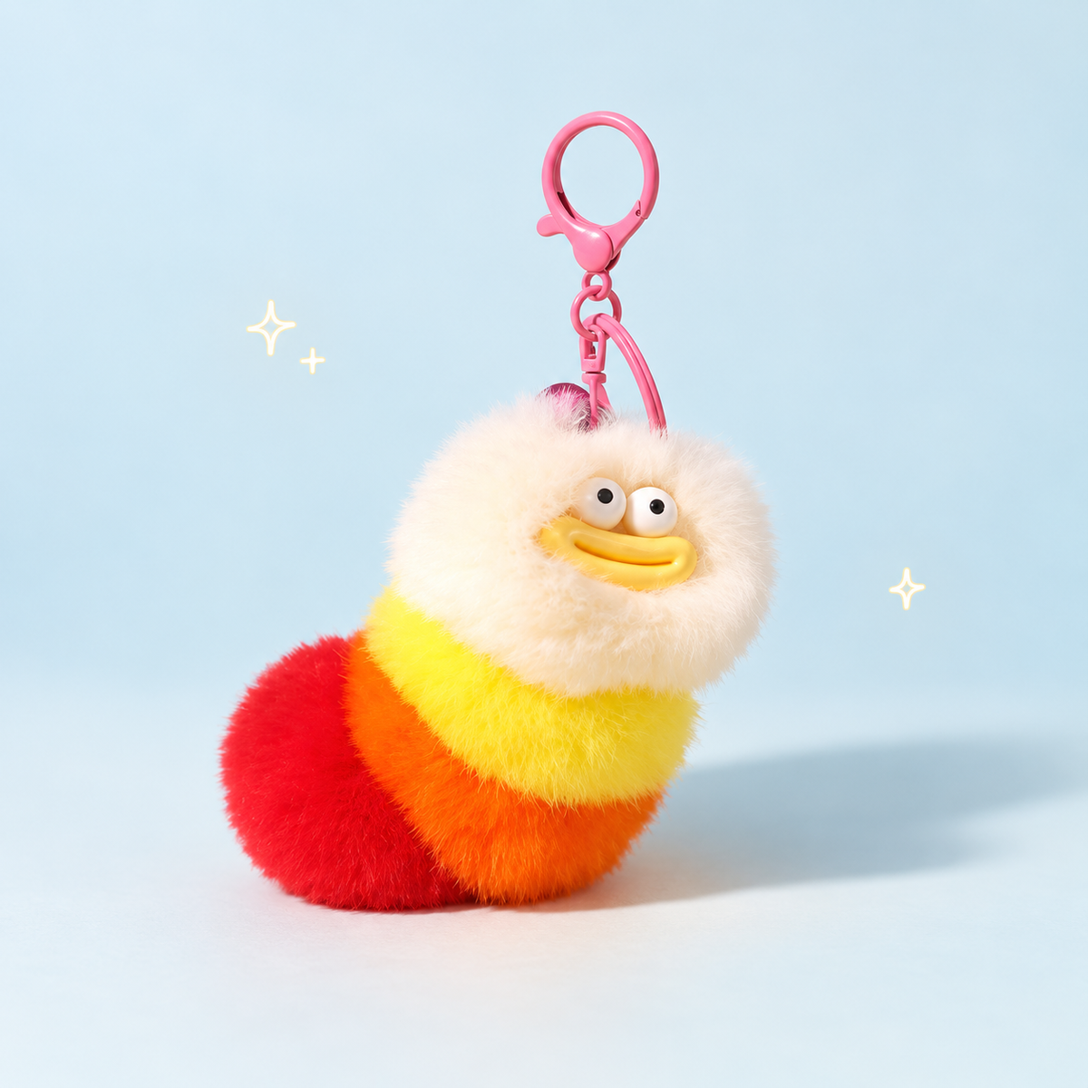 Caterpillar Plush Charm on a softly lit cream and pastel background.