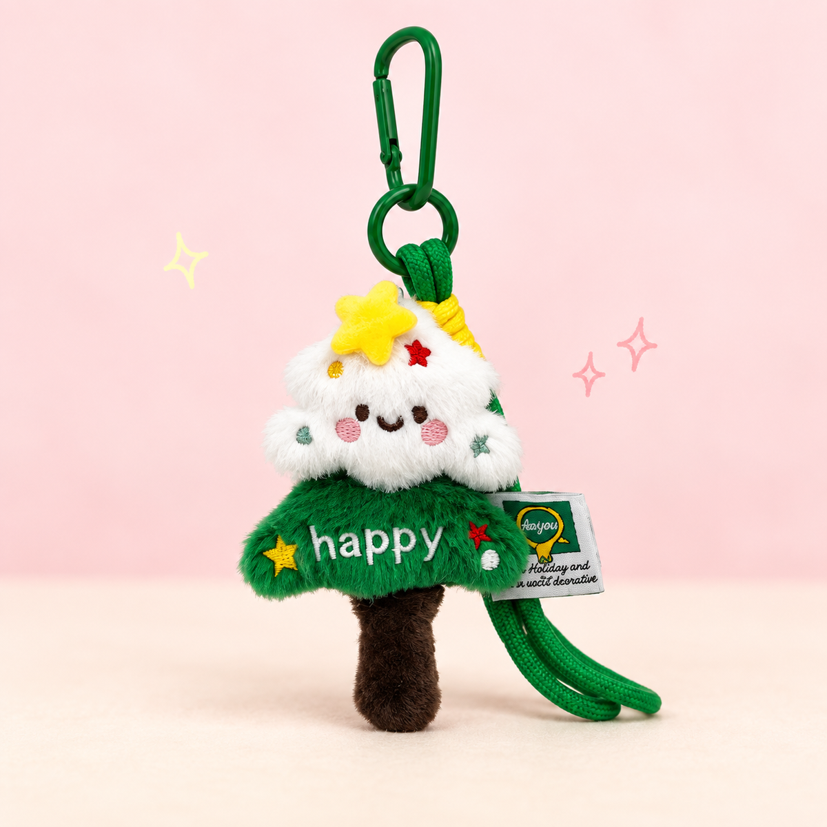 Christmas Tree Plush Charm on a softly lit cream and pastel background.