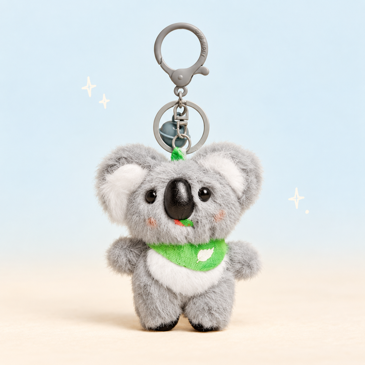 Green Scarf Koala Plush Charm on a softly lit cream and pastel background.