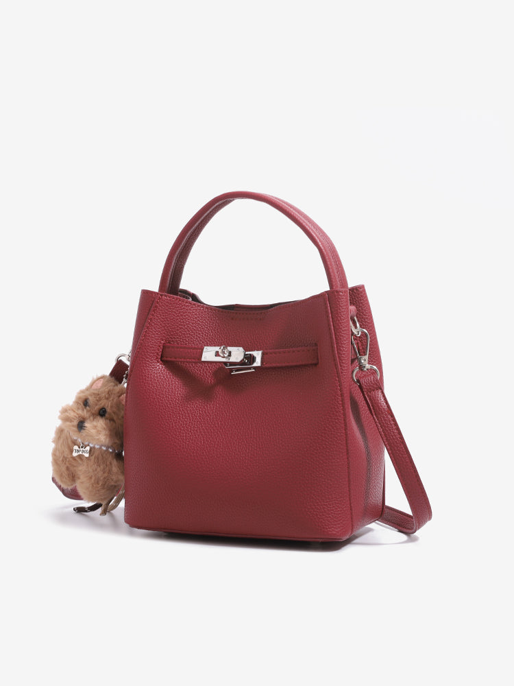 Close front view of wine red mini bucket bag, textured PU surface and dog charm