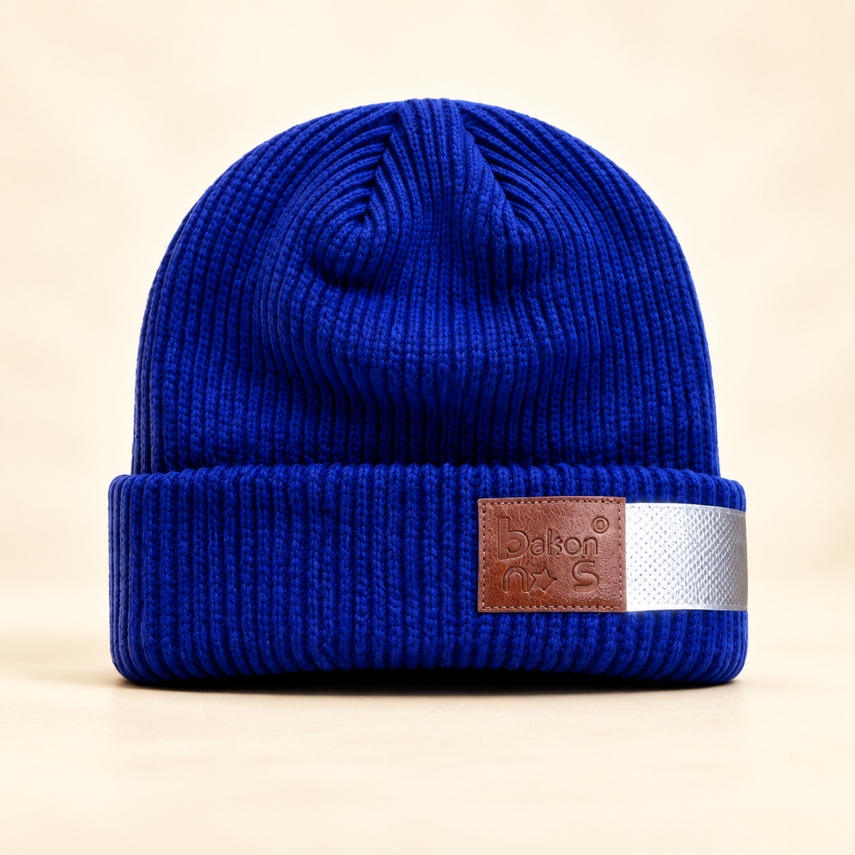 That bakons Reflective Knit Beanie on a softly lit cream and pastel background.