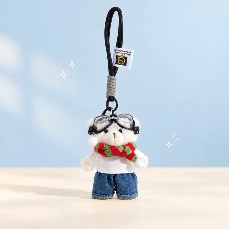Aviator Bear Plush Charm on a softly lit cream and pastel background.