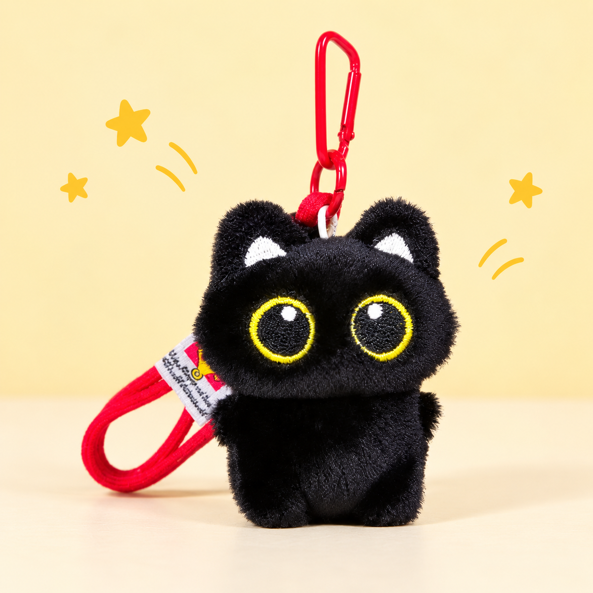 Black Cat Plush Keychain on a softly lit cream and pastel background.