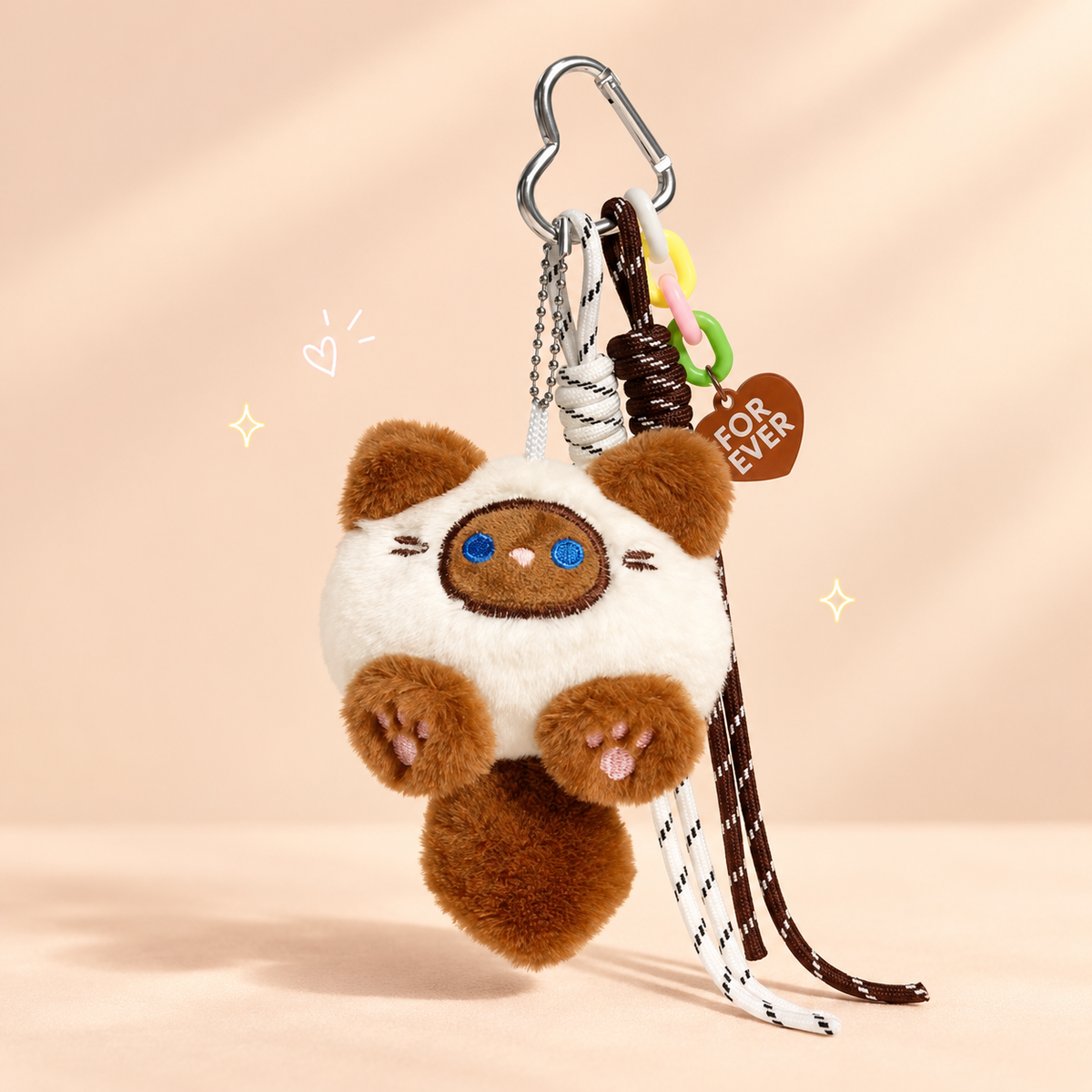 Brown cat plush keychain on a softly lit cream and pastel background.