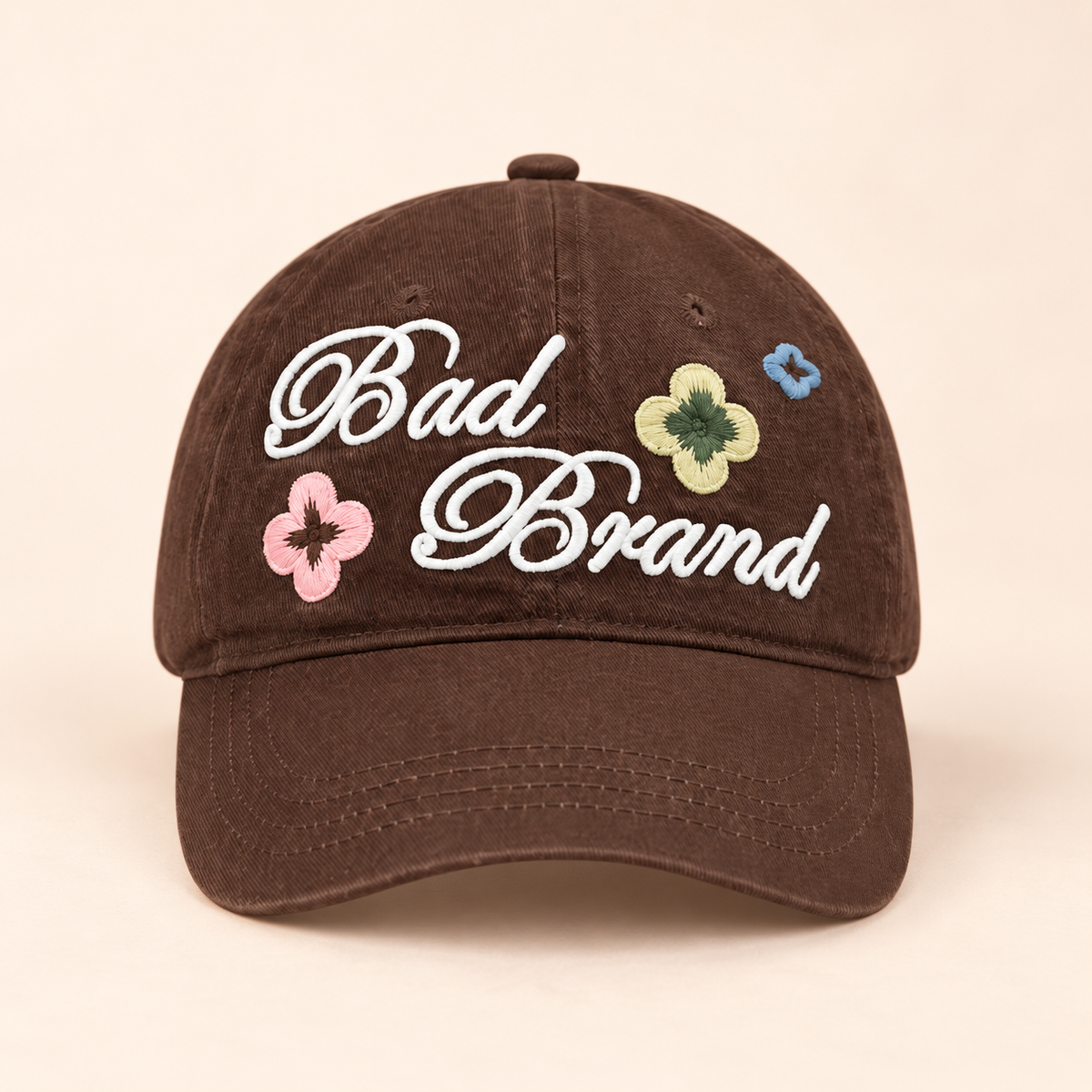 Floral Script Baseball Cap on a softly lit cream and pastel background.