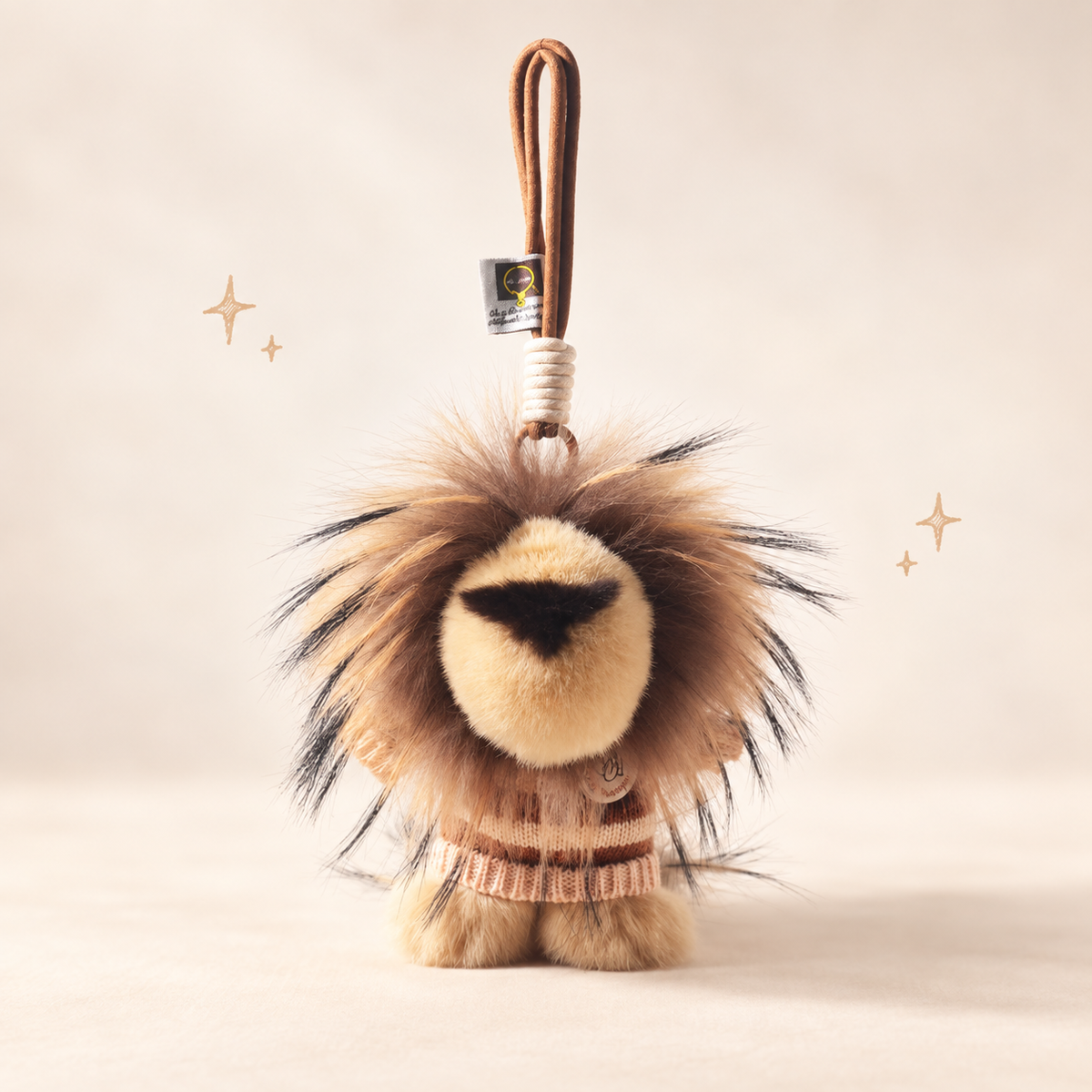 Lion Plush Charm on a softly lit cream and pastel background.