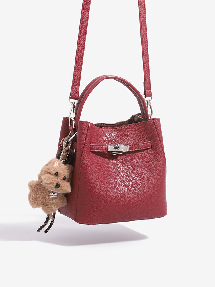 Wine red mini bucket bag hanging from its shoulder strap