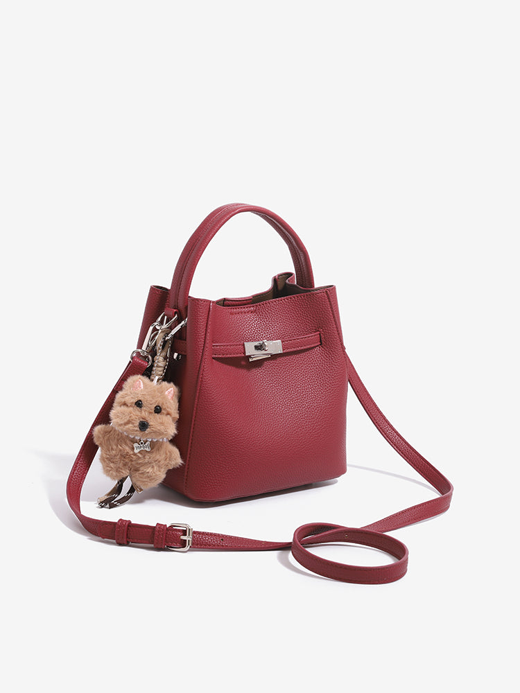 Three-quarter view of wine red mini bucket bag with extended adjustable strap